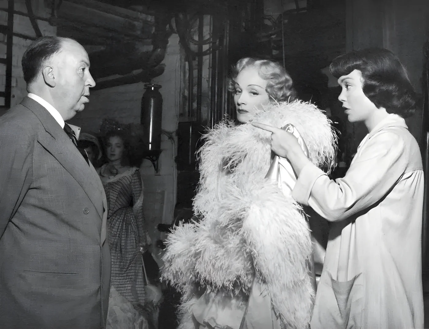 German-American actress Marlene Dietrich and American actress Jane Wyman, with British director and producer Alfred Hitchcock on the set of his movie Stage Freight, 1950
