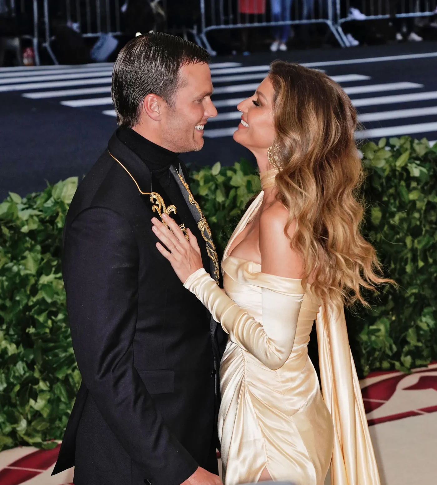 Gisele Bündchen and Tom Brady pose together on a red carpet.