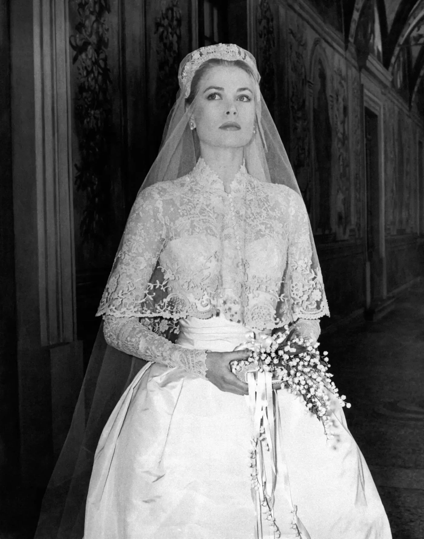 Grace Kelly photographed in her bridal dress in a frescoed gallery within the Prince