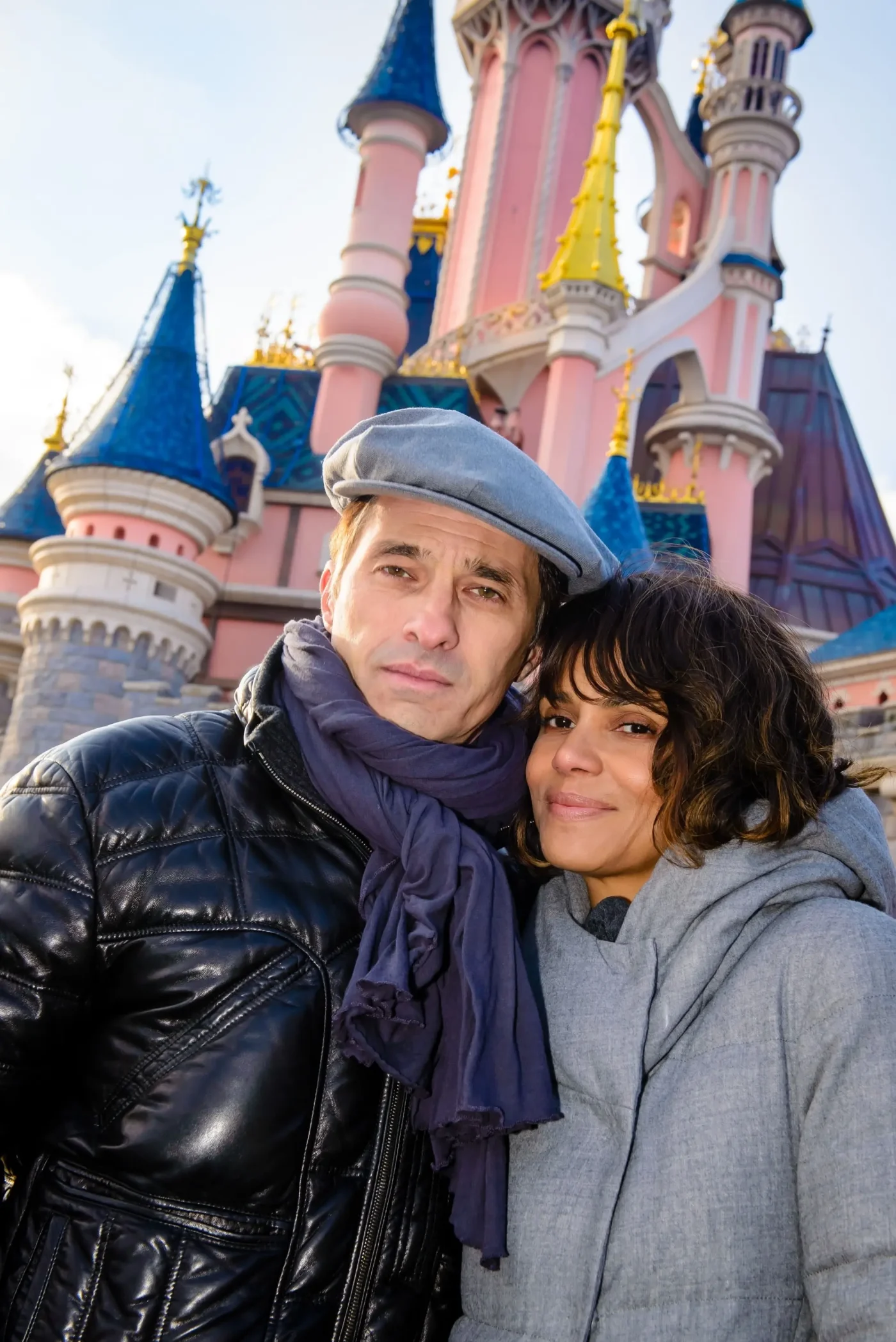 Halle Berry and Olivier Martinez pose in front of Sleeping Beauty Castle at Disneyland Paris.