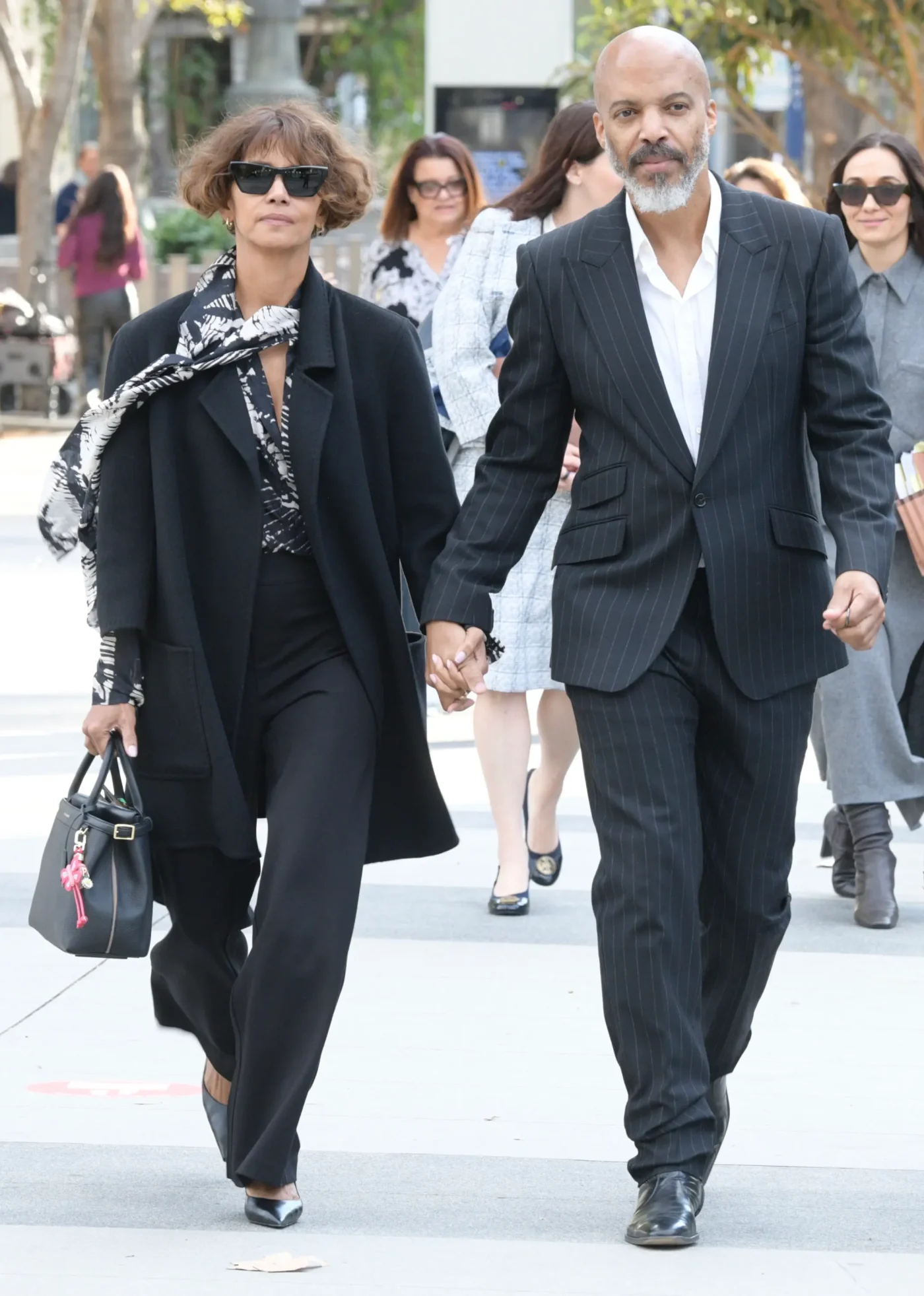 Halle Berry and Van Hunt holding hands and walking together.