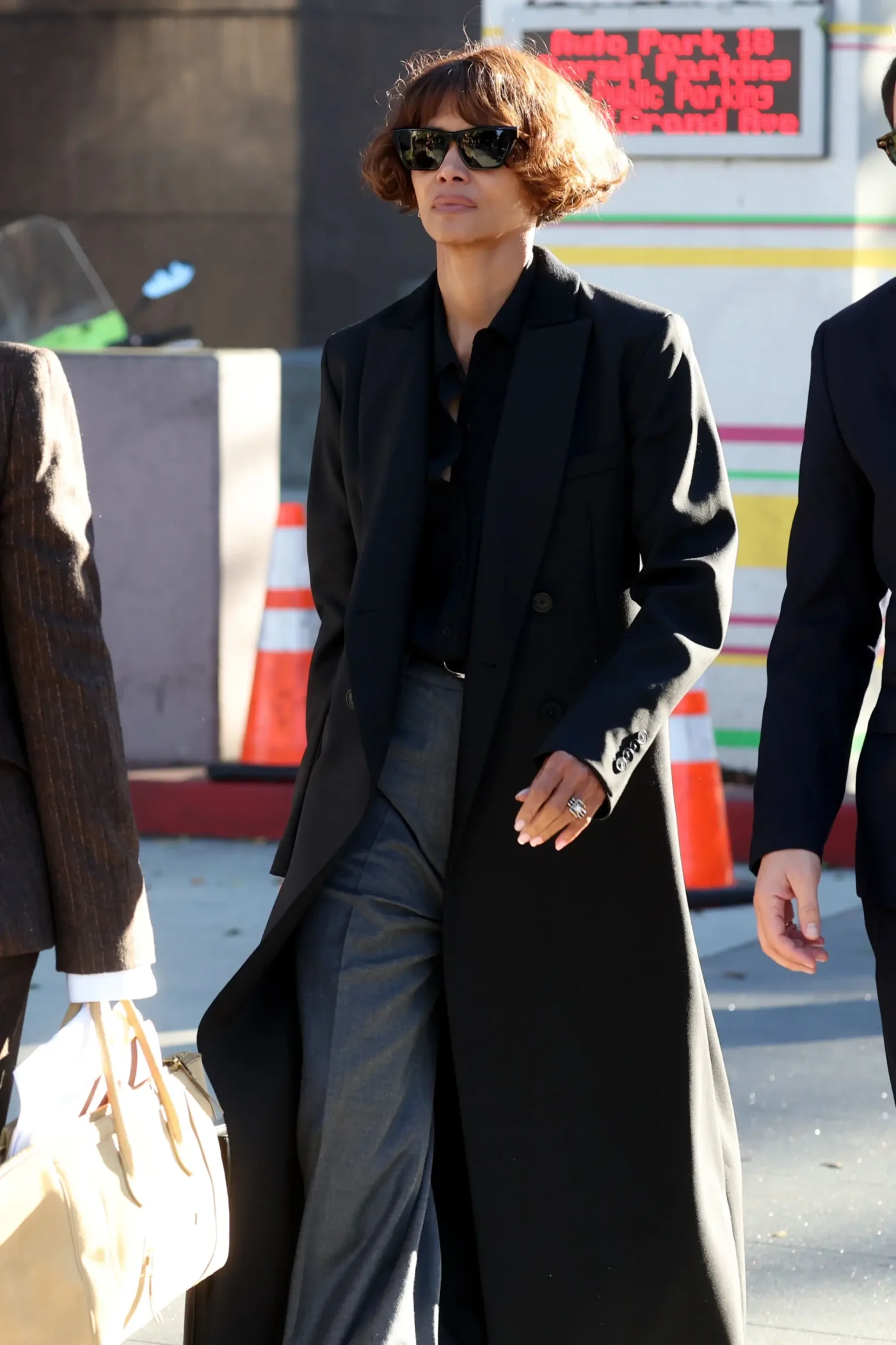 Halle Berry leaves the courthouse wearing a black coat and sunglasses.