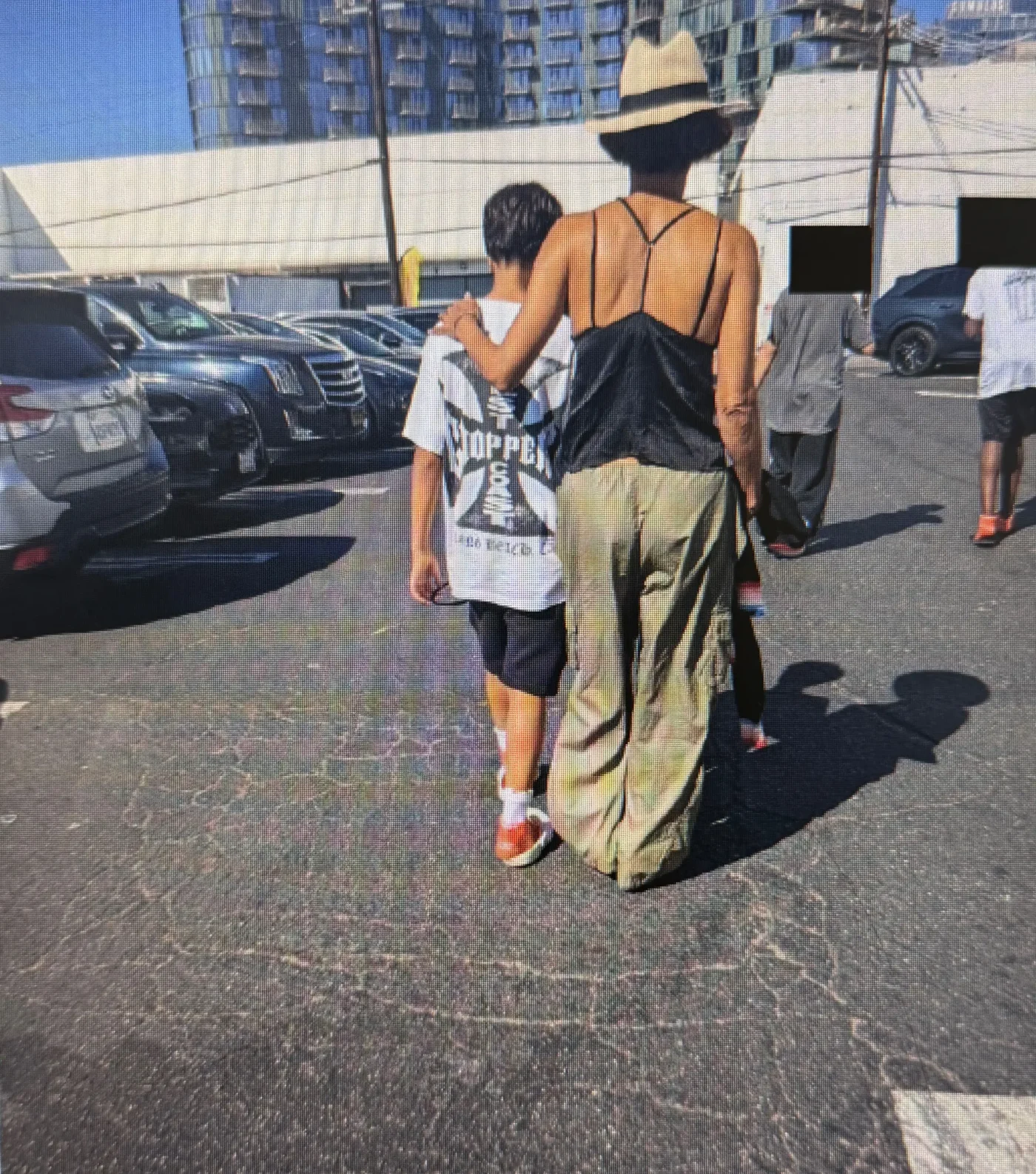 Halle Berry walking with her son Maceo in a parking lot.