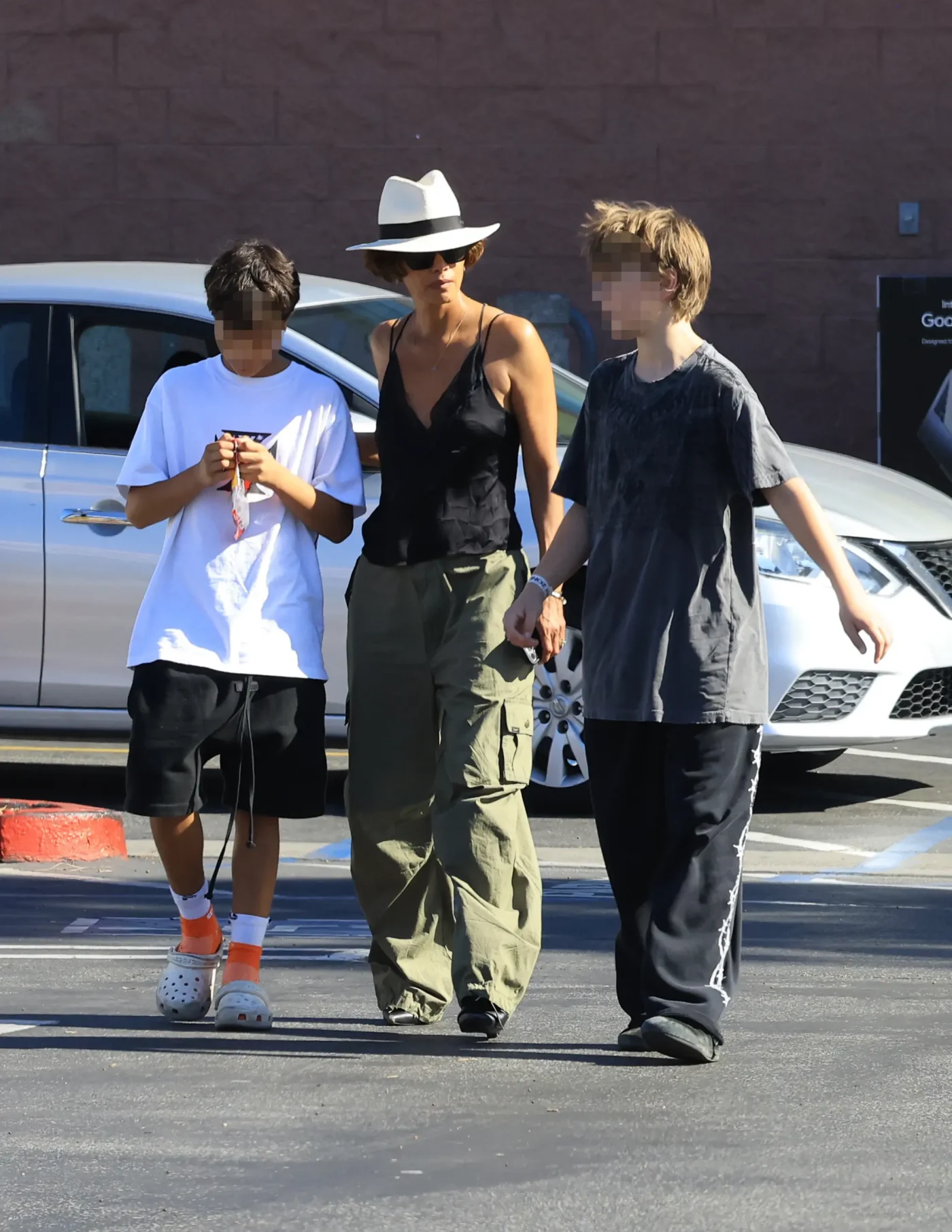 Halle Berry walks through a parking lot with two children.