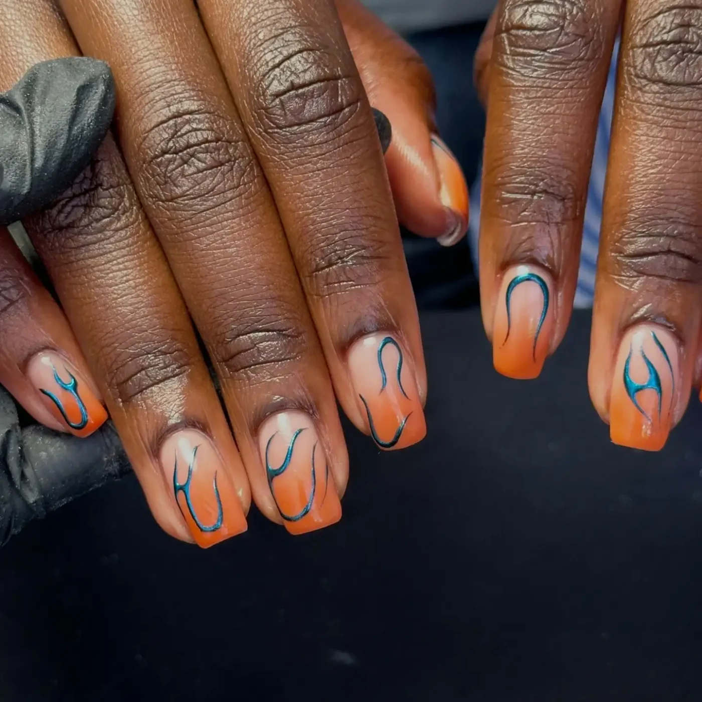 Hands with decorated nails featuring a curved and wavy design