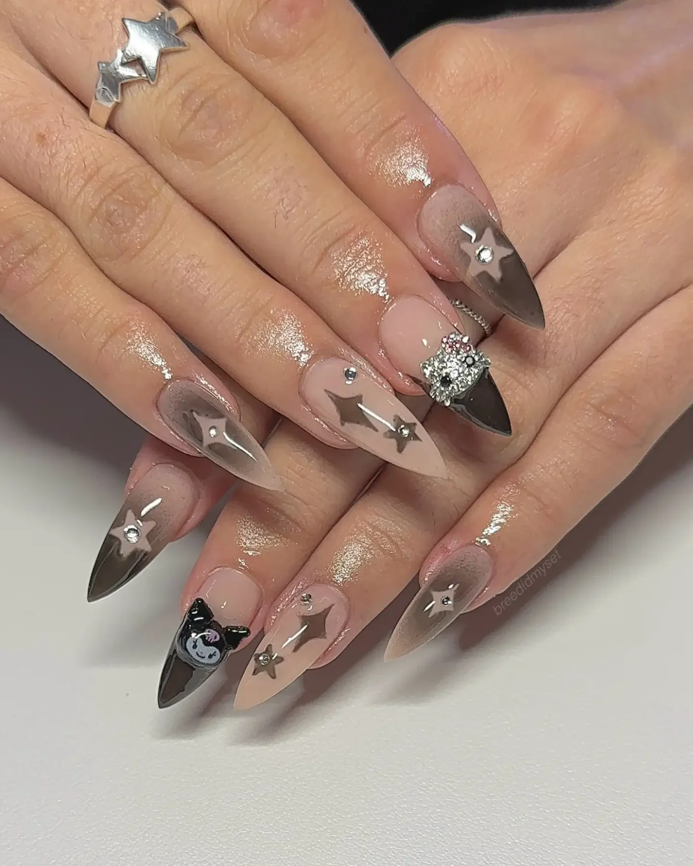 Hands with intricate nail art featuring star accents and unique designs