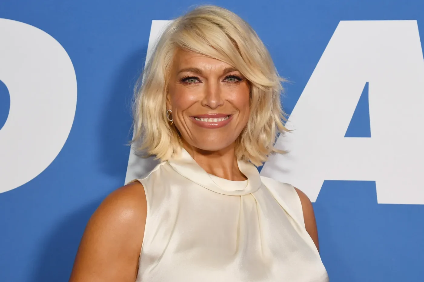 Hannah Waddingham smiling against a blue background