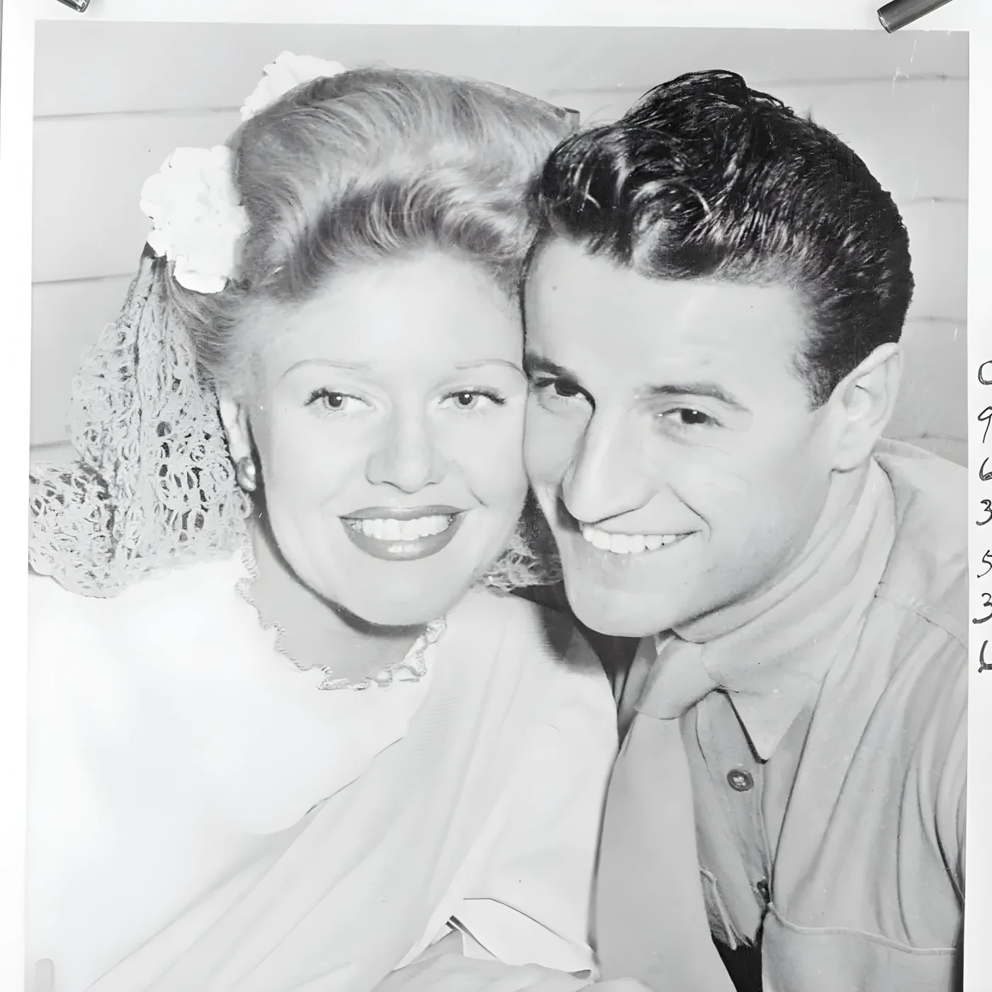 Happy as only honeymooners have a right to be, movie star Ginger Rogers and her husband, Private John Calvin Briggs of the US Marine Corps, pose for their photograph in their home after returning from a short honeymoon. Private Briggs used to be a bit player in the movies before he became a Leatherneck.