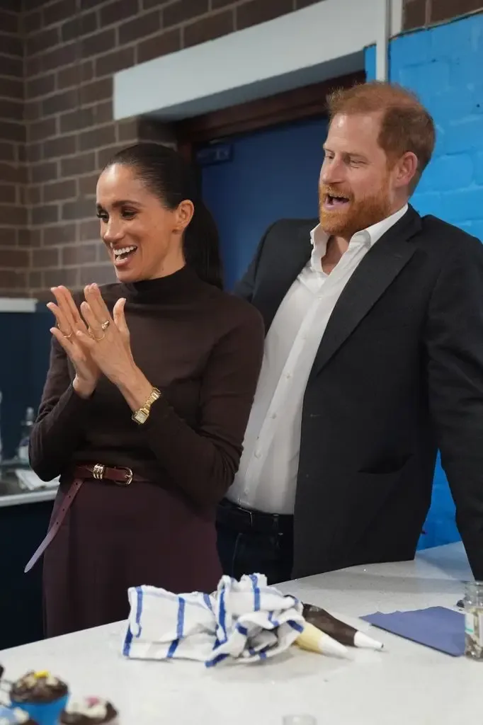 Harry couldn't resist playing with Meghan's ponytail as they sang 'Happy birthday'