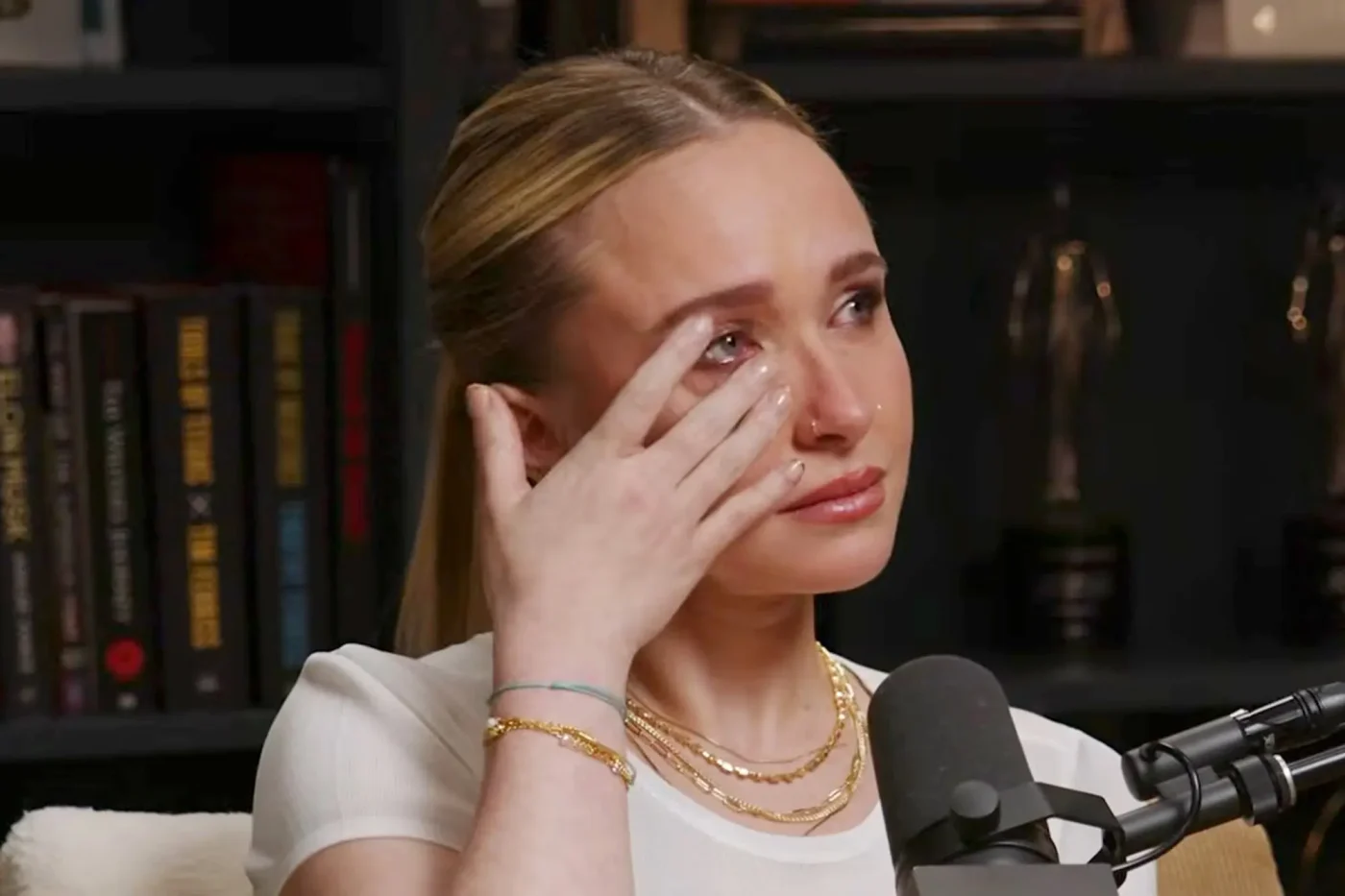 Hayden Panettiere wiping a tear from her eye during an interview.