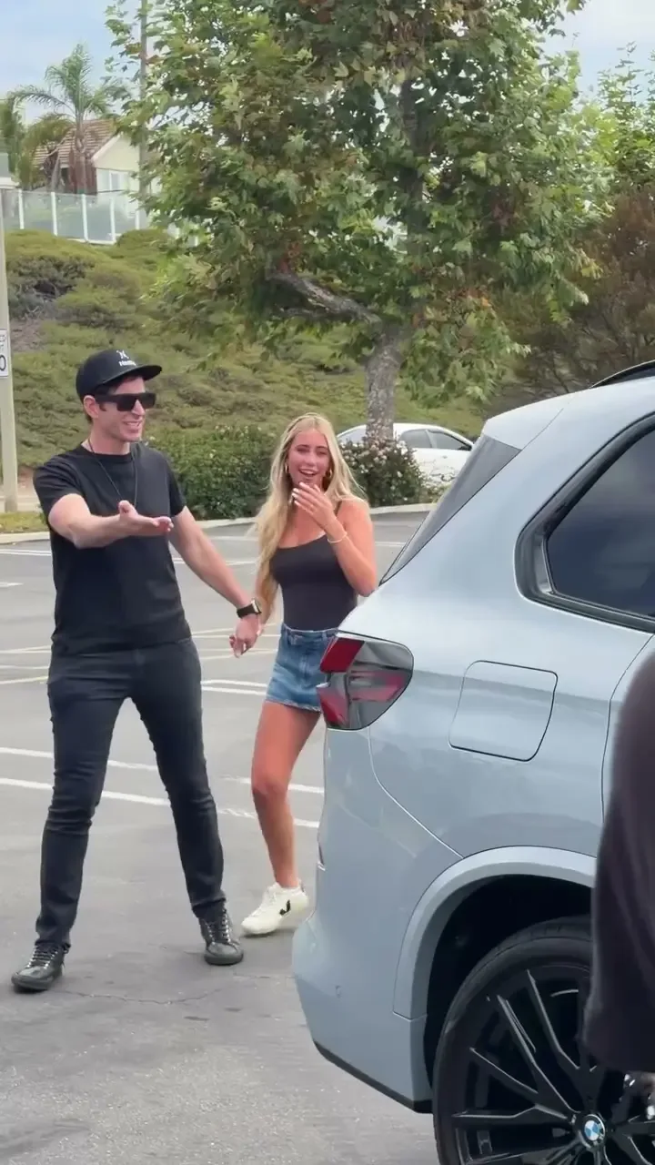 HGTV star and his 16-year-old daughter smiling near her new BMW.