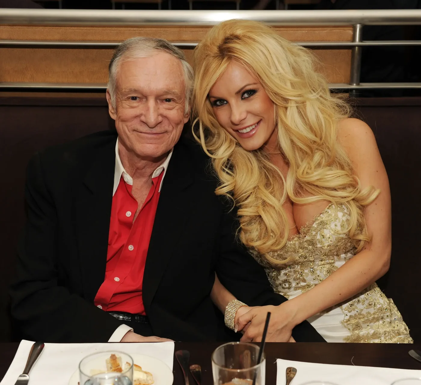 Hugh Hefner and Crystal Harris sitting together at a table.