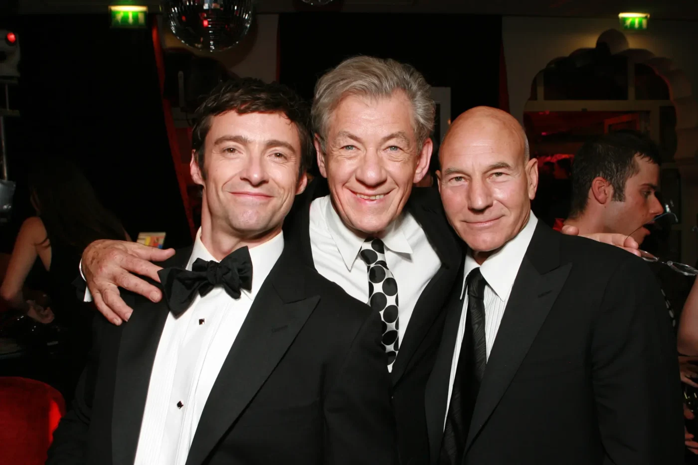 Hugh Jackman, Ian McKellen, and Patrick Stewart pose together at an event.