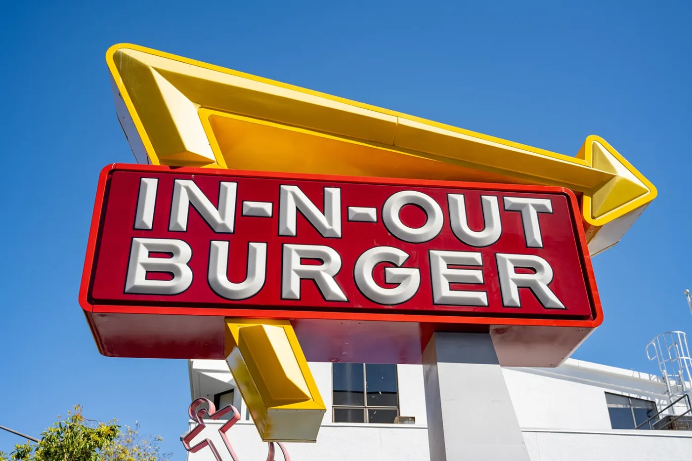 In-N-Out Burger sign with red and yellow logo against clear blue sky outside a building, San Francisco, California, April 17, 2026.