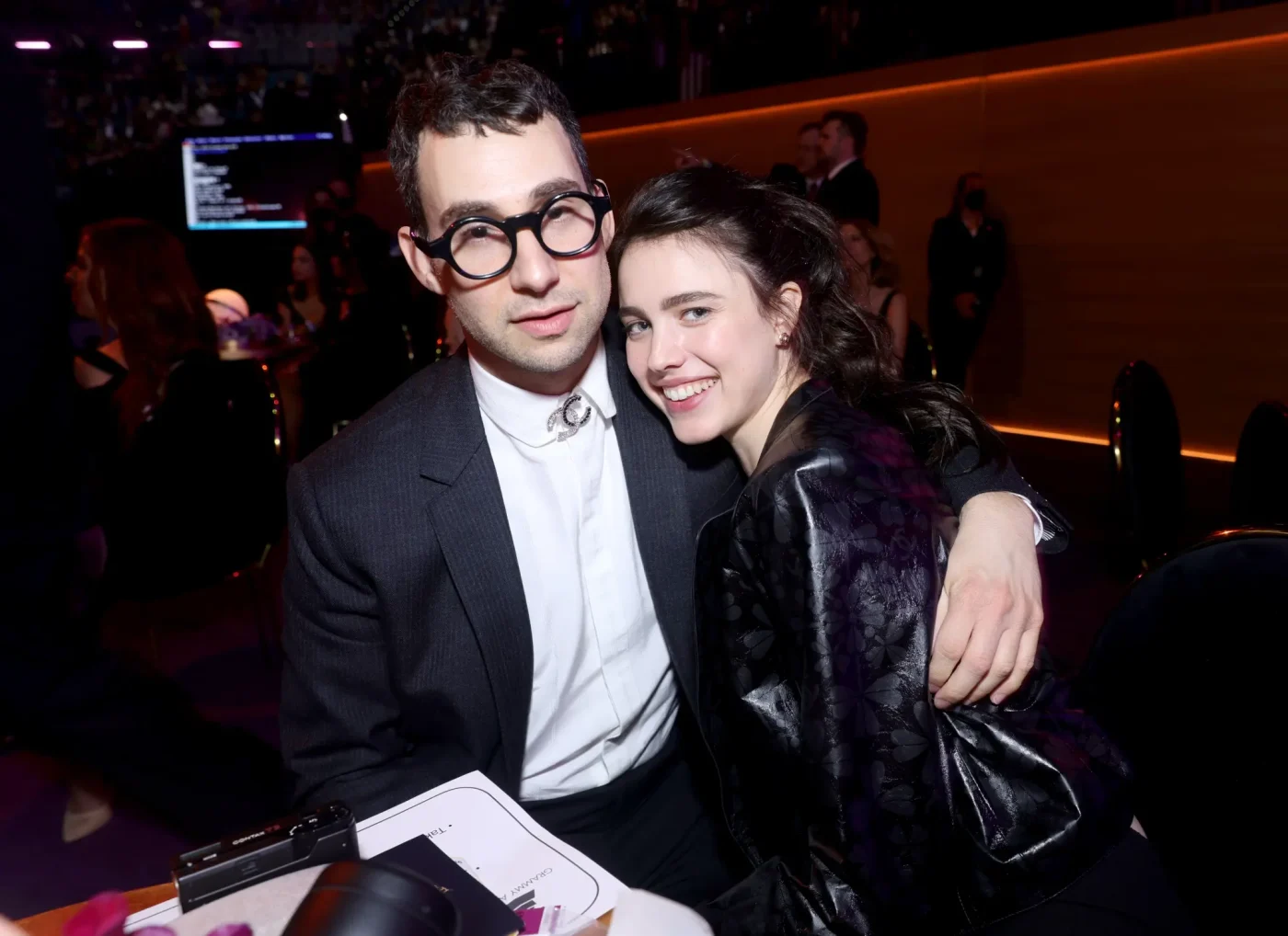 Jack Antonoff and Margaret Qualley smiling and sitting together at the 64th Annual Grammy Awards.
