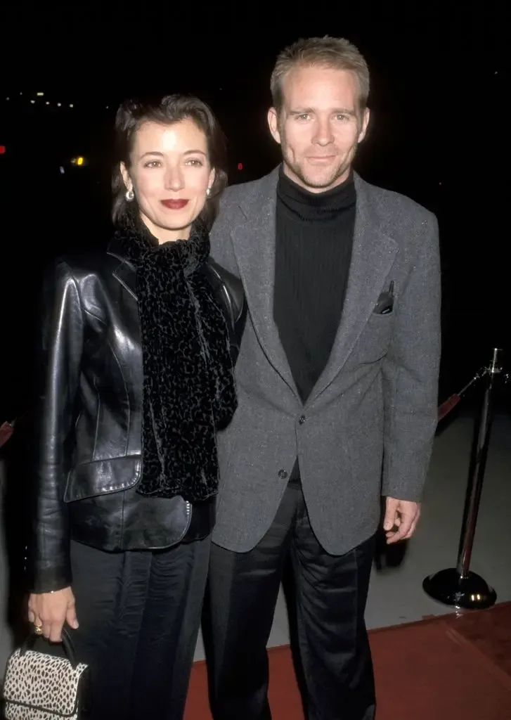 Jason Connery and Mia Sara standing together on a red carpet, both smiling.