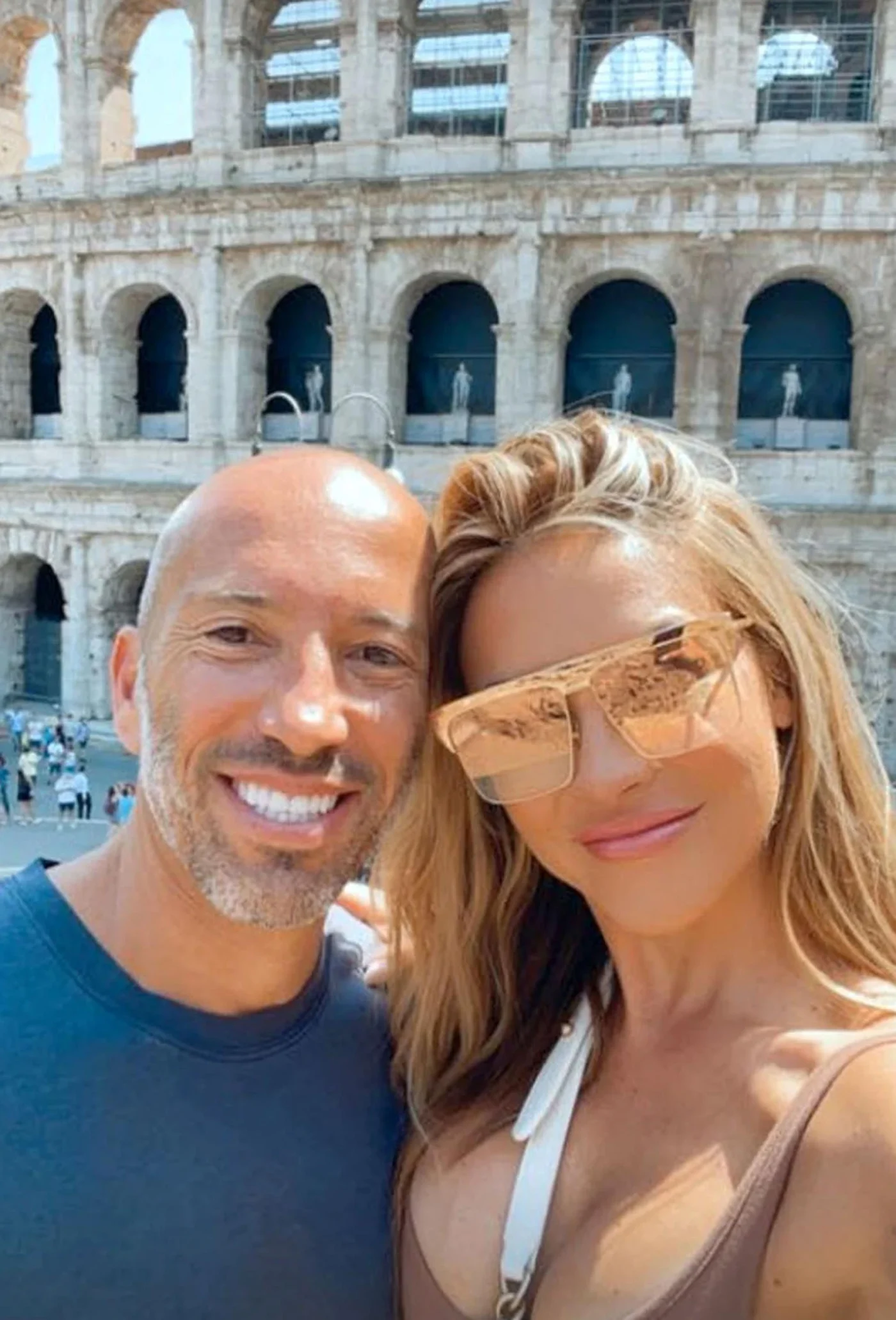 Jason Oppenheim and Chrishell Stause posing in front of the Colosseum in Rome.