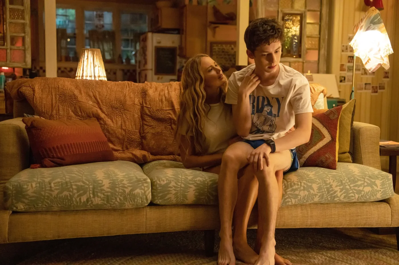 Jennifer Lawrence and Andrew Barth Feldman seated on a couch in a scene from the film No Hard Feelings.