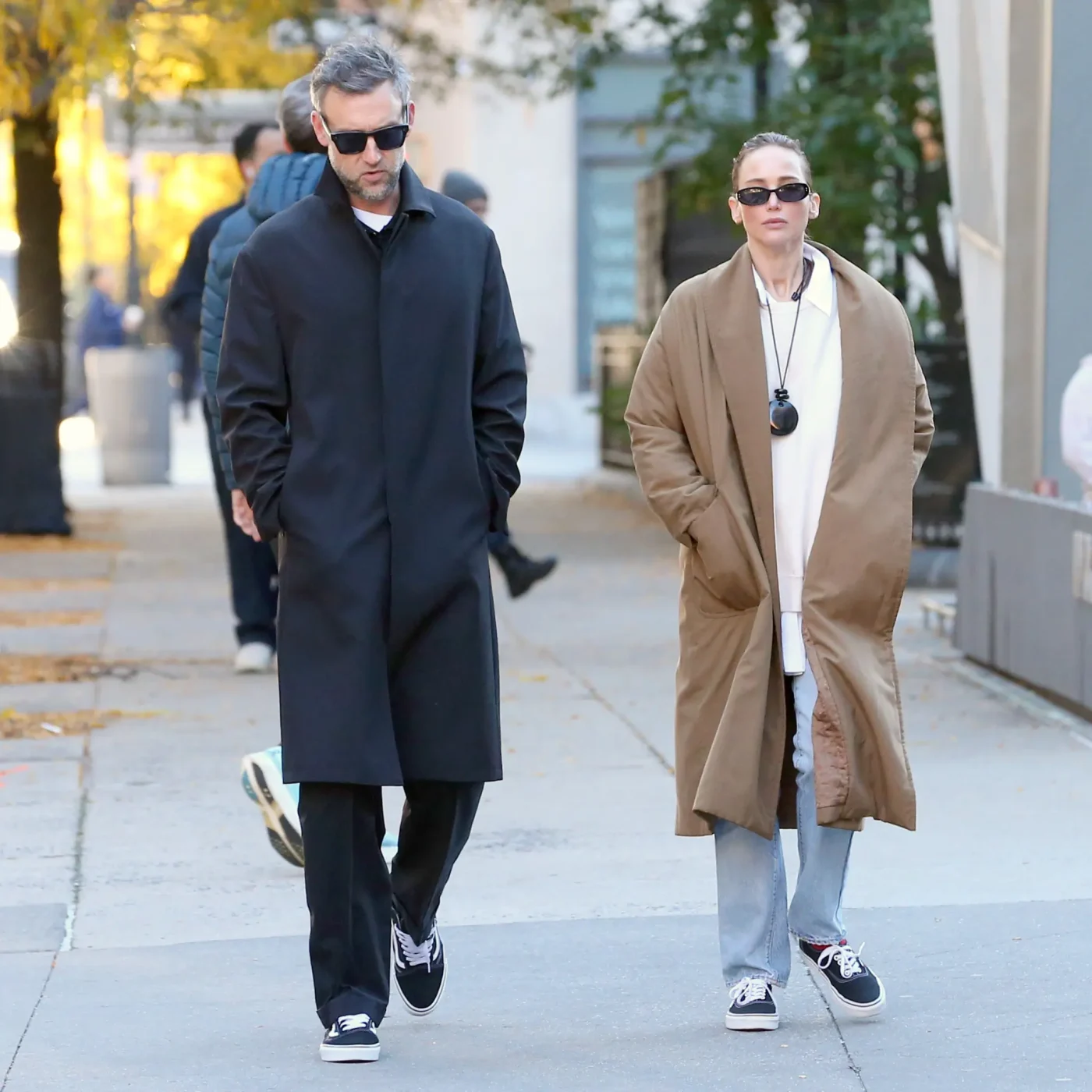Jennifer Lawrence and Cooke Maroney walk together on a New York City street, both wearing matching black and white Vans sneakers.