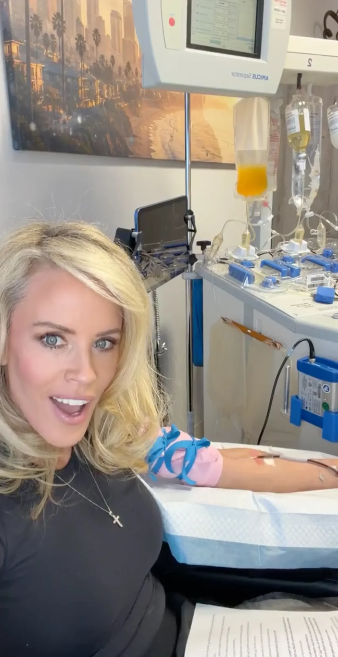 Jenny McCarthy smiling while hooked up to an IV and medical equipment.