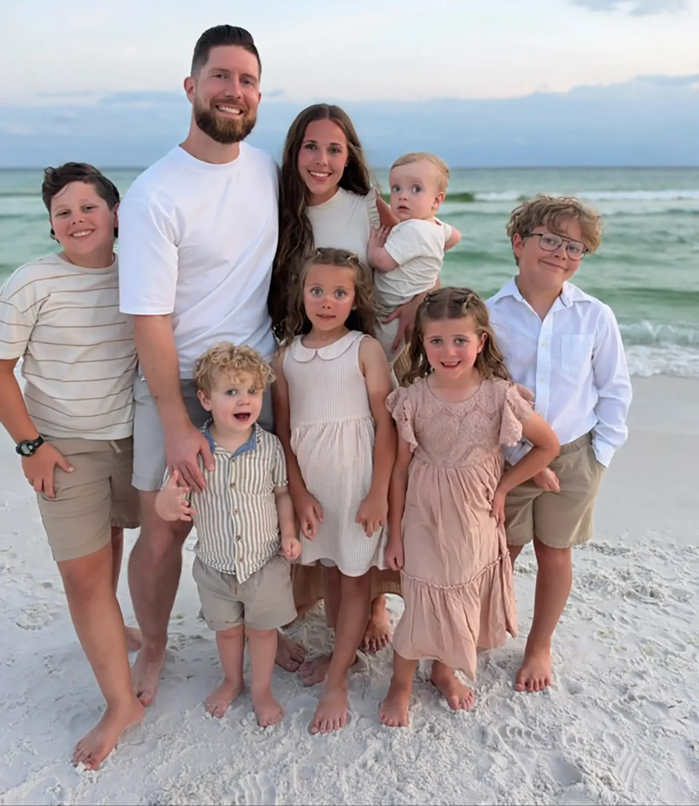 Jessa Duggar and Ben Seewald pose with their six children on a beach.