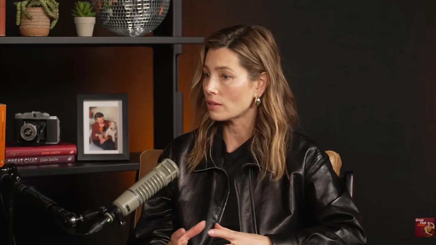 Jessica Biel sitting in front of a microphone, speaking during an interview.