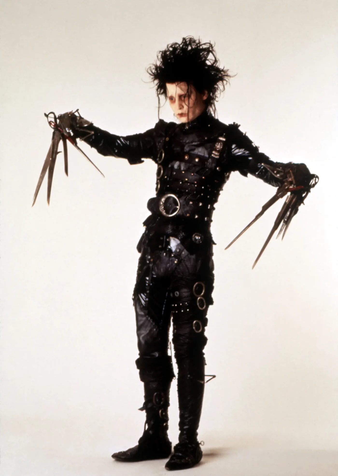 Johnny Depp as Edward Scissorhands wearing a black leather outfit with scissor blades for hands.