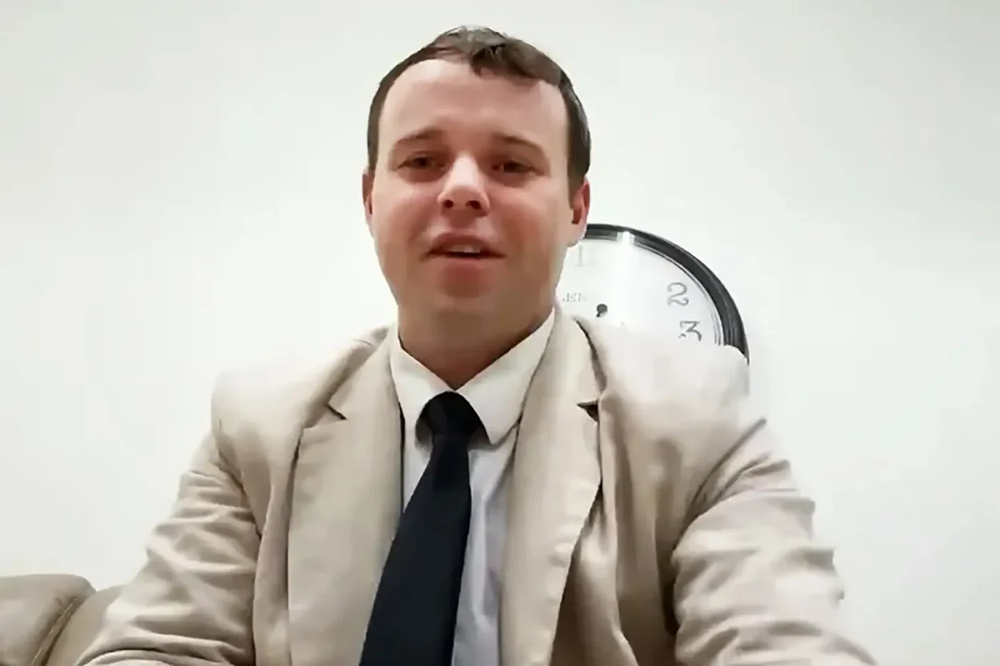 Joseph Duggar in a beige suit and dark tie.