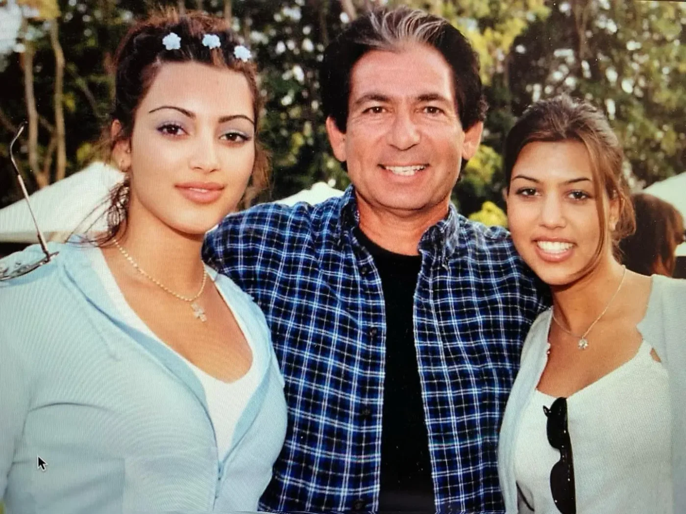 Kim and Kourtney Kardashian posing with their father Robert Kardashian.