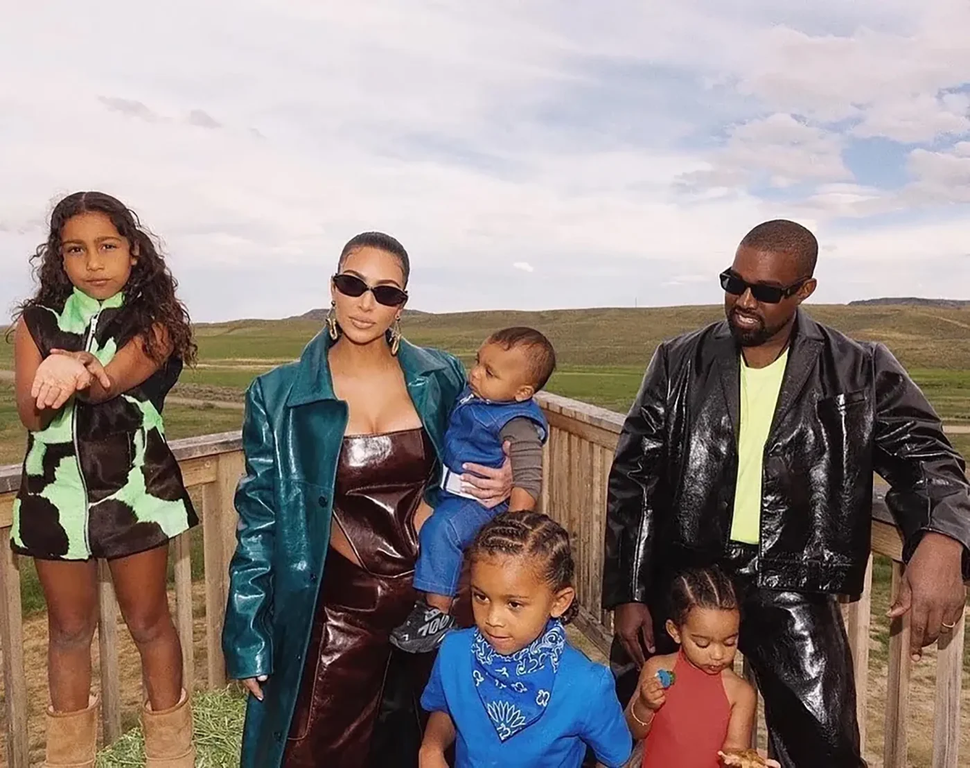 Kim Kardashian and Kanye West with their children outdoors.