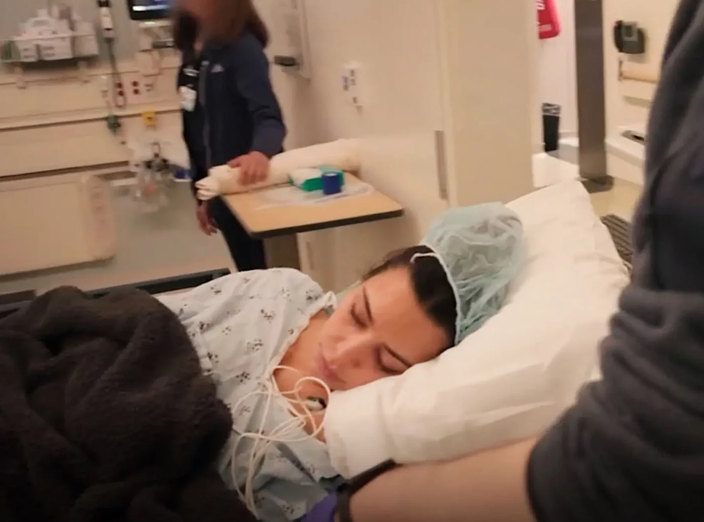 Kim Kardashian lying in a hospital bed with medical equipment.