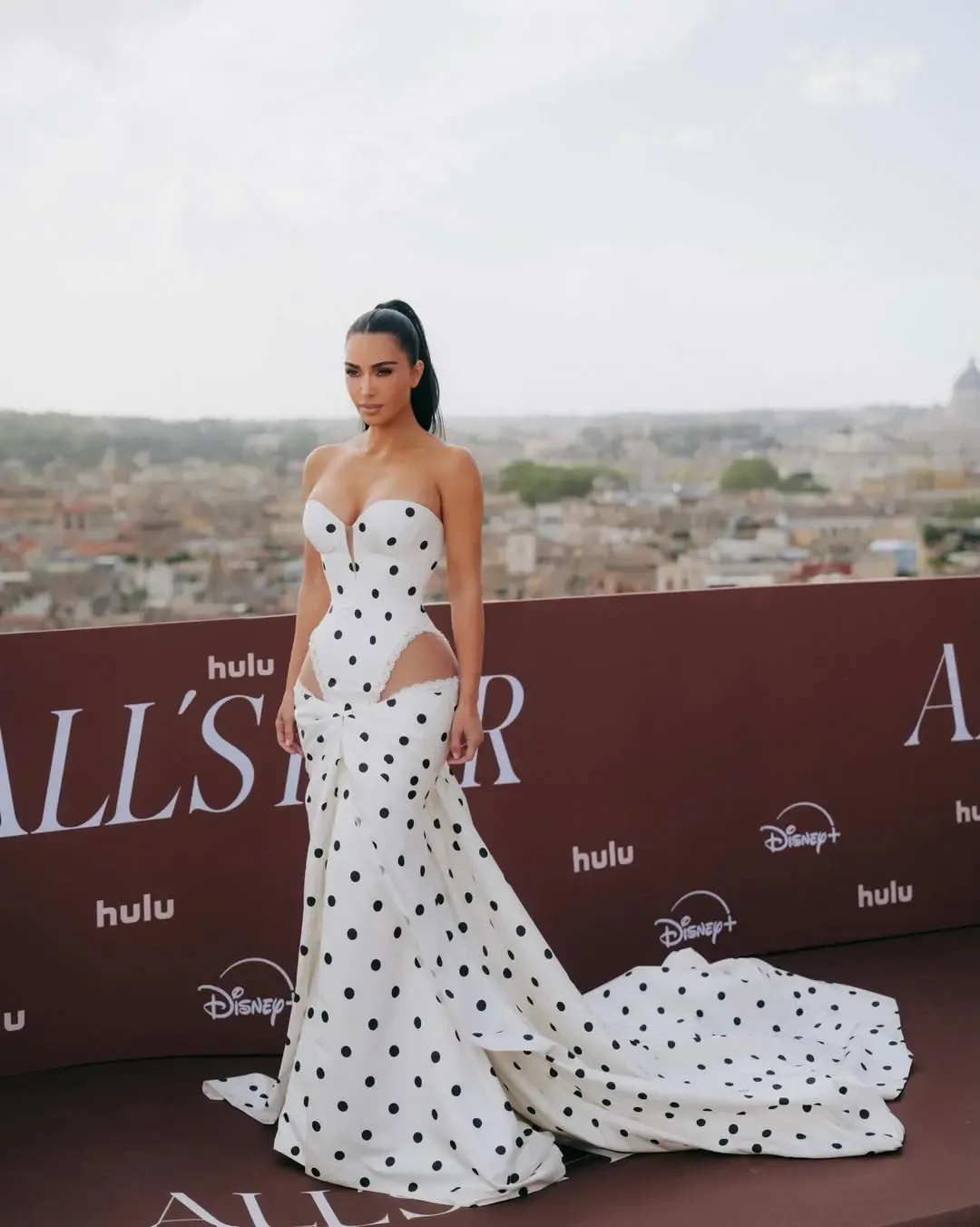Kim Kardashian wearing a white and black polka dot gown during a press event in Rome.