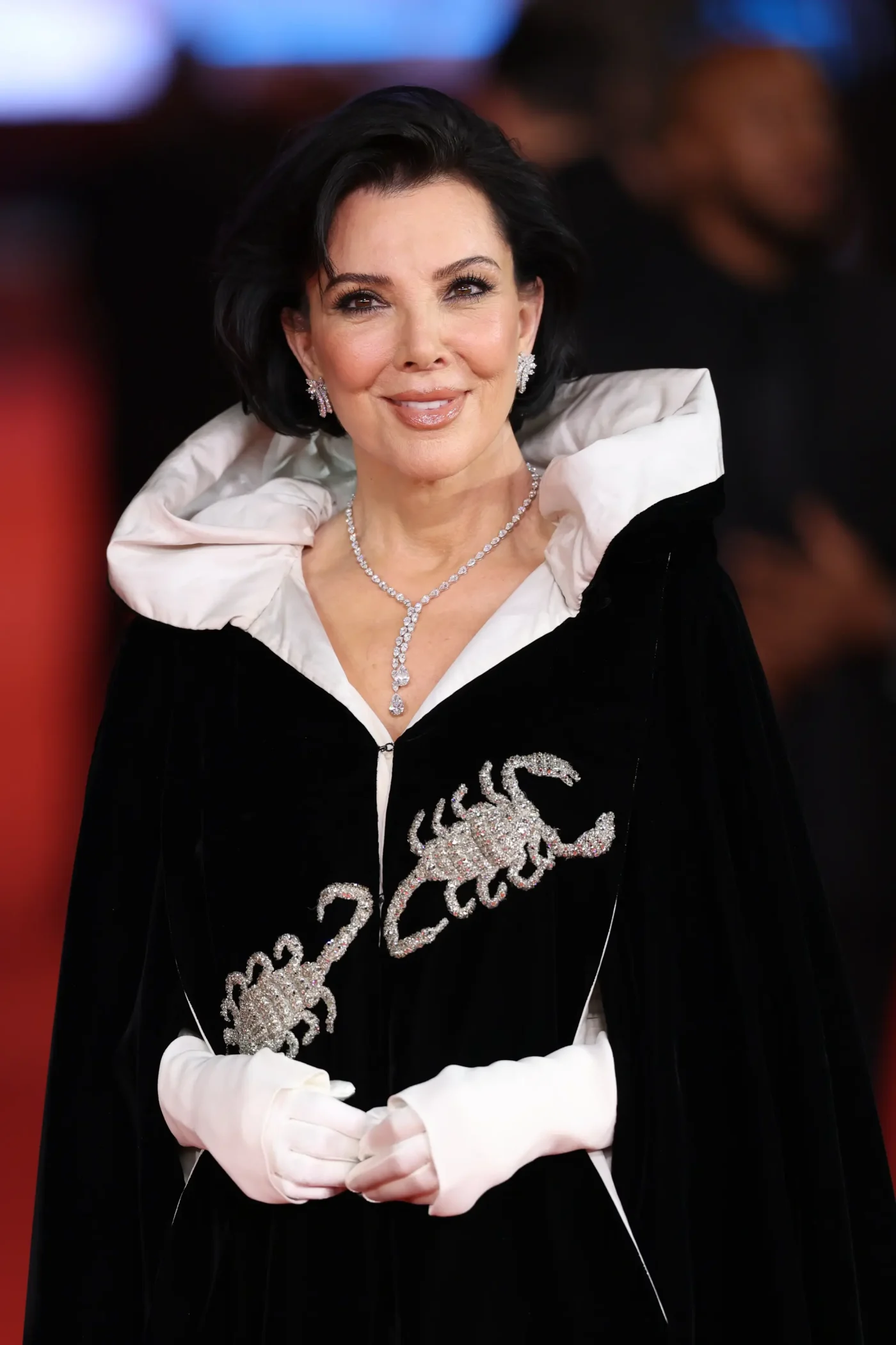 Kris Jenner wearing a black and white cape with crystal scorpion embellishments at the "All