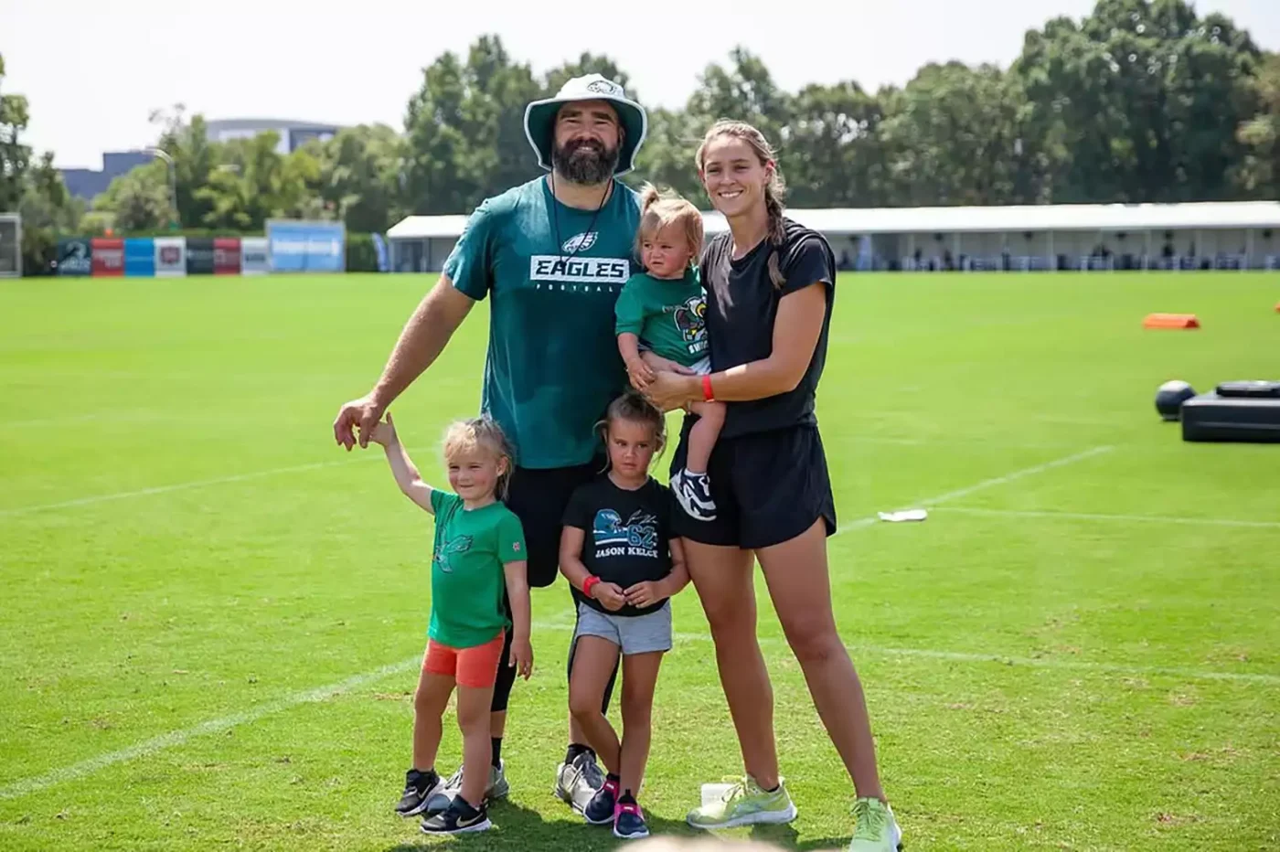 Kylie Holding Daughter Bennett With Wyatt and Elliott Leaning Against Jason Kelce on Football Field