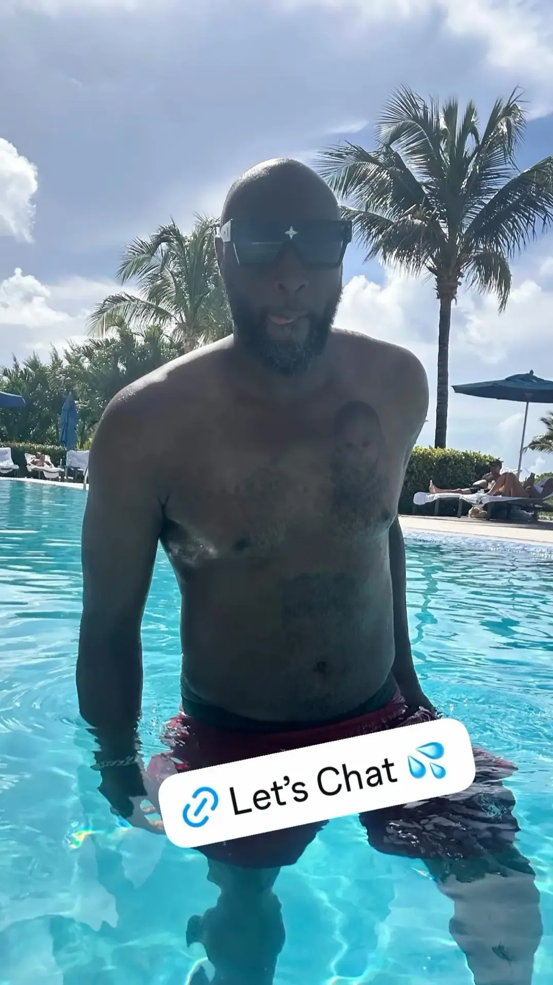 Lamar Odom standing in a swimming pool wearing sunglasses with a "Let