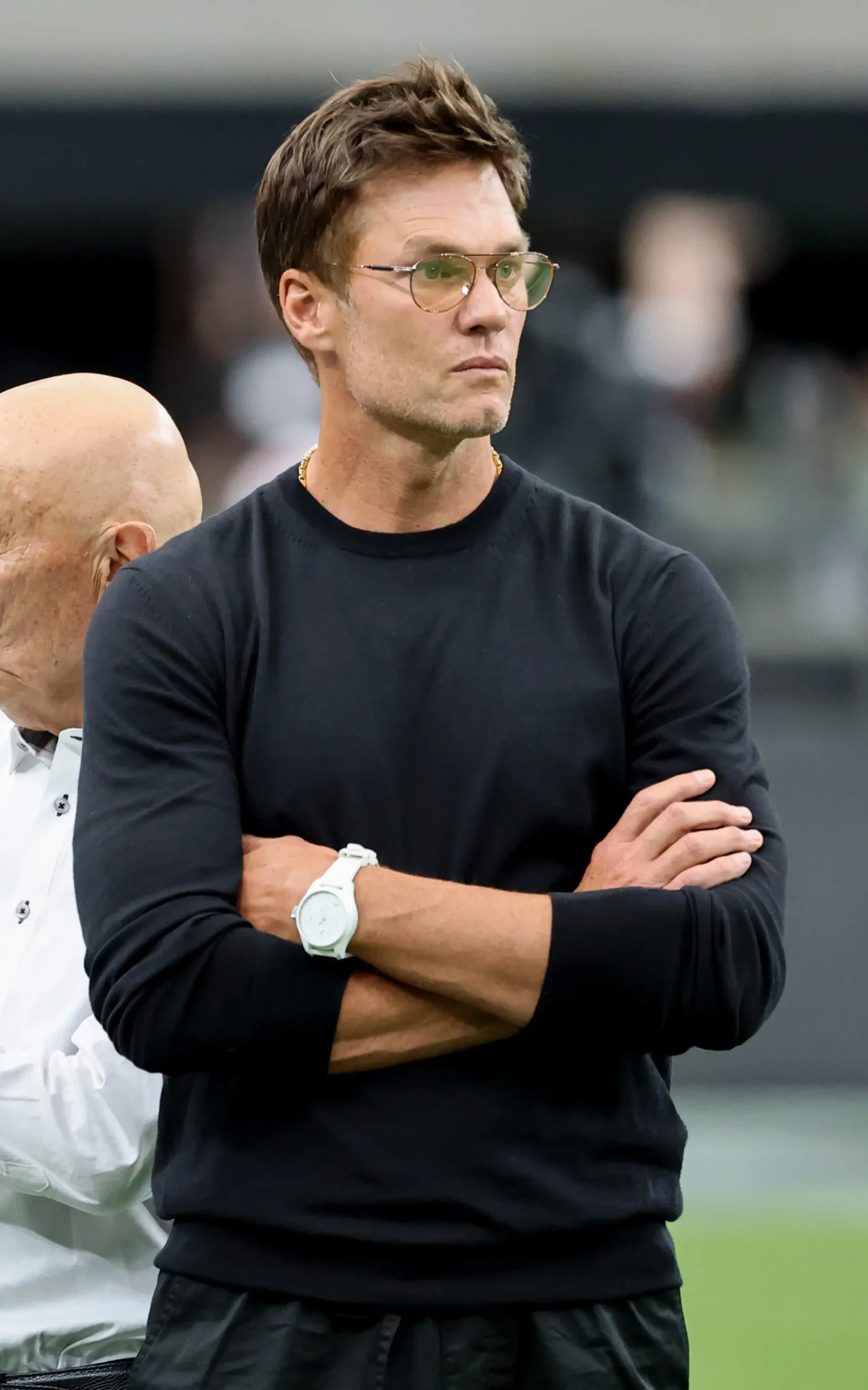 Las Vegas Raiders minority owner Tom Brady looks on with his arms crossed during warmups before a game.