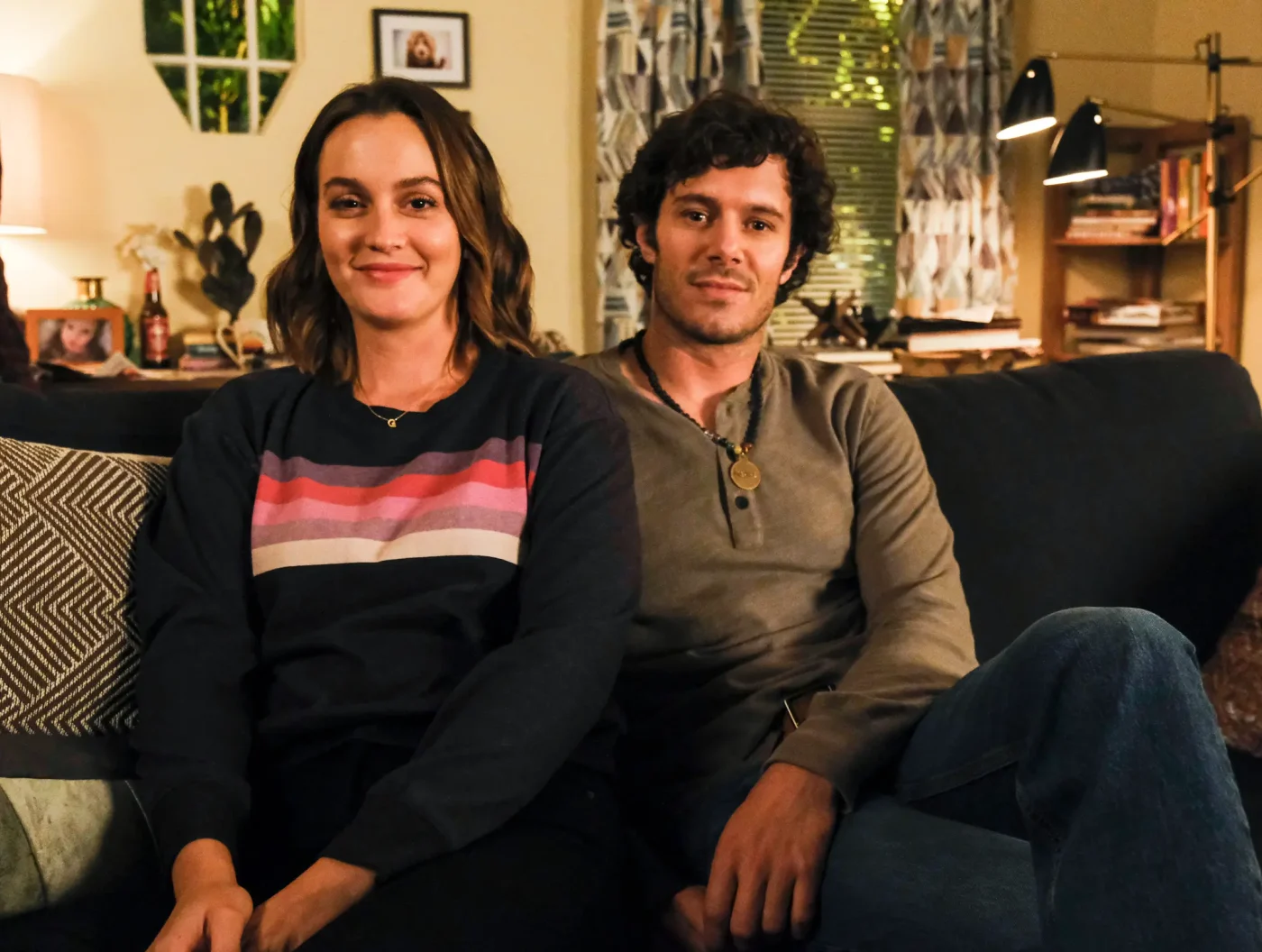 Leighton Meester and Adam Brody sitting on a couch in