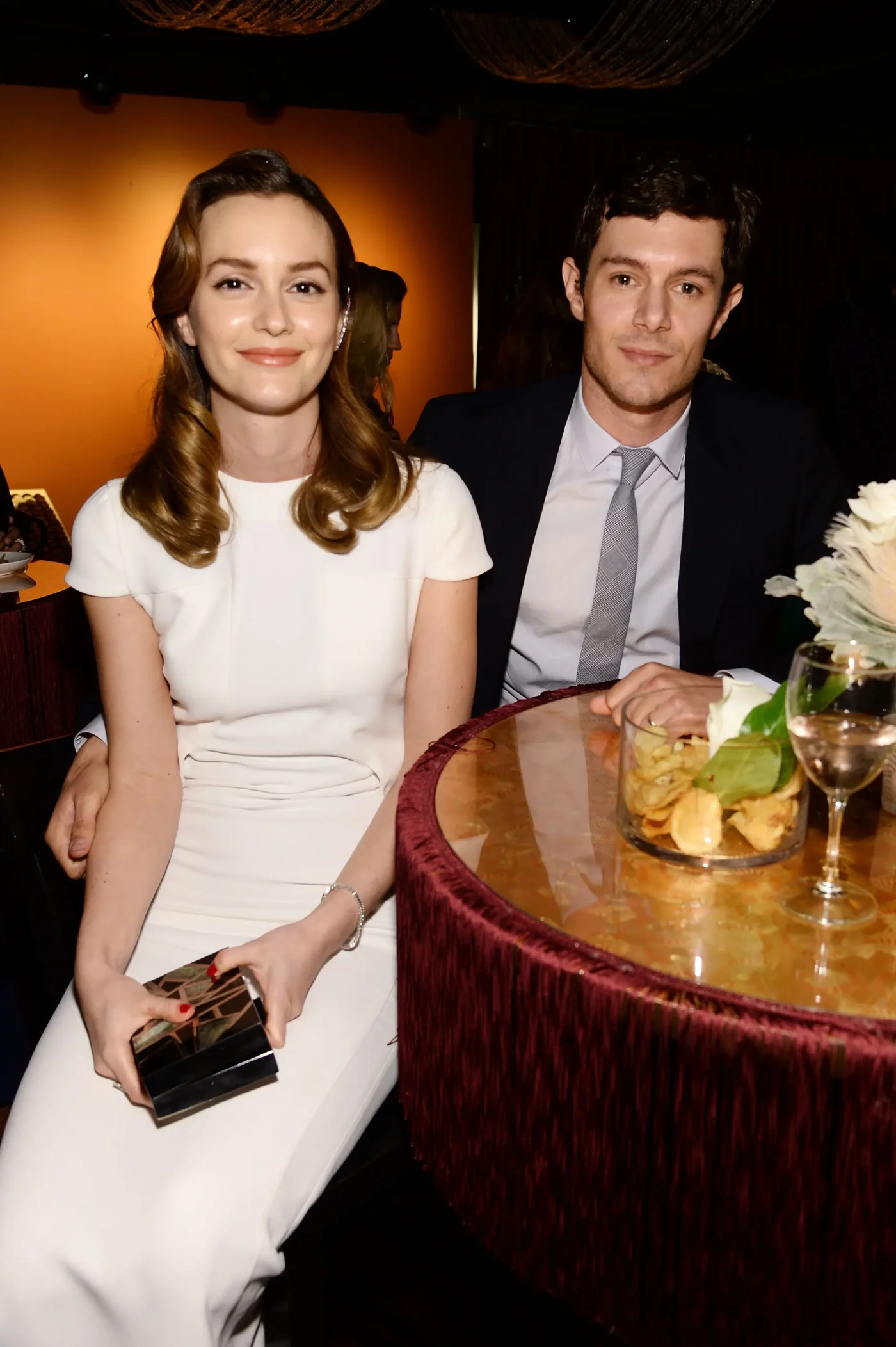 Leighton Meester and Adam Brody sitting together at a table.