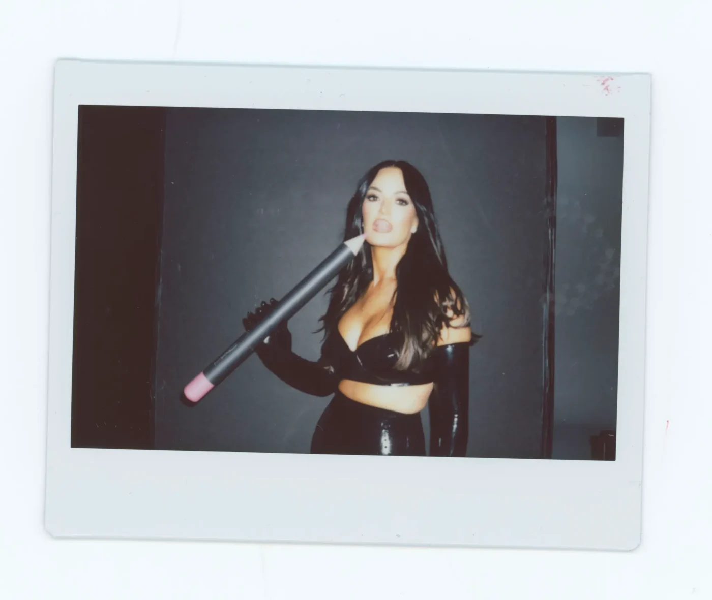 Lisa Barlow holding a giant MAC lip pencil in a Polaroid-style photo.