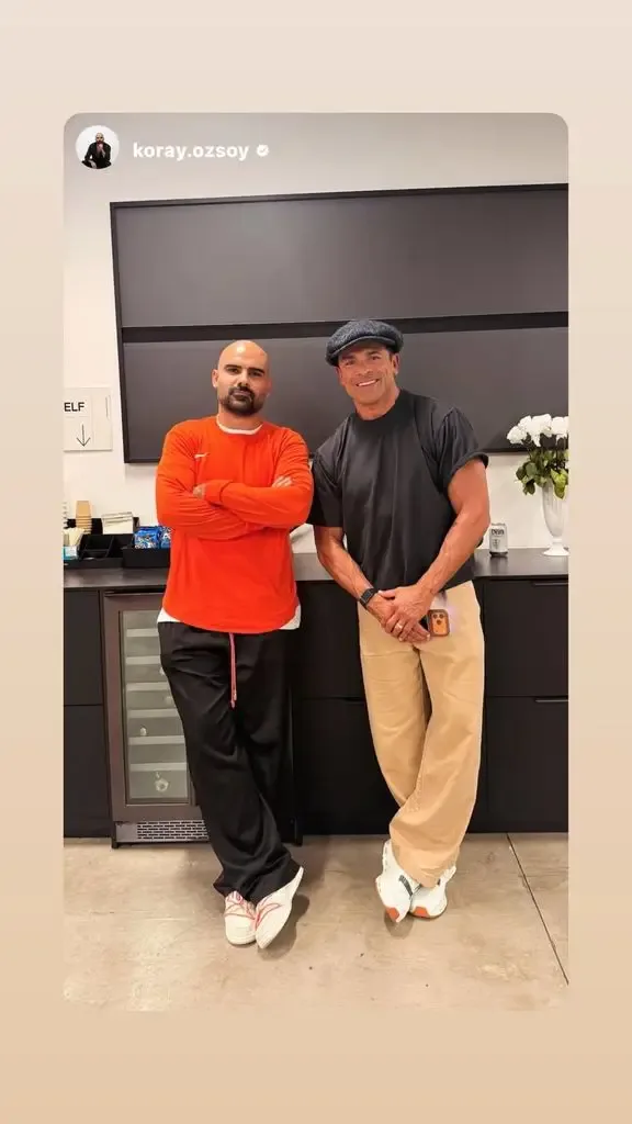Mark posing next to a tattoo artist