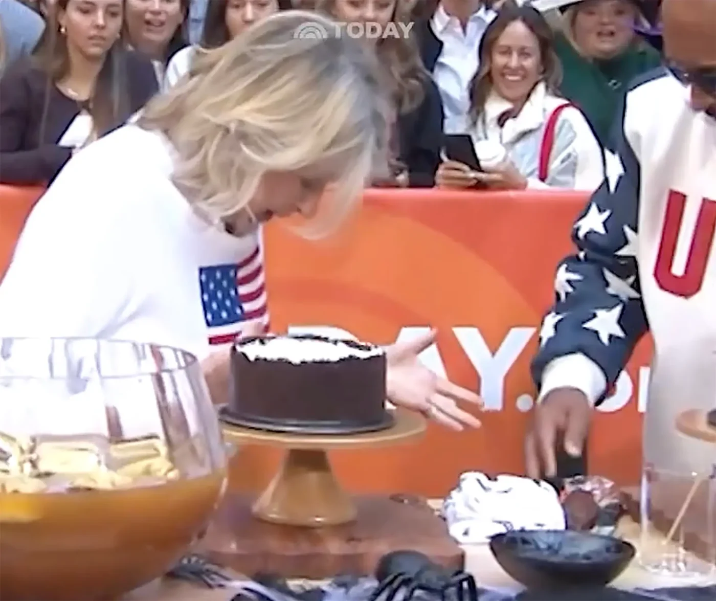 Martha Stewart leans over a cake on a stand during a Today segment.