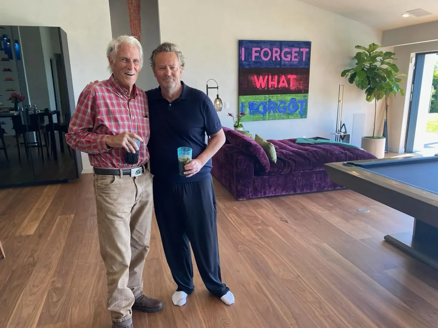 Matthew Perry and his father John standing together inside a room.