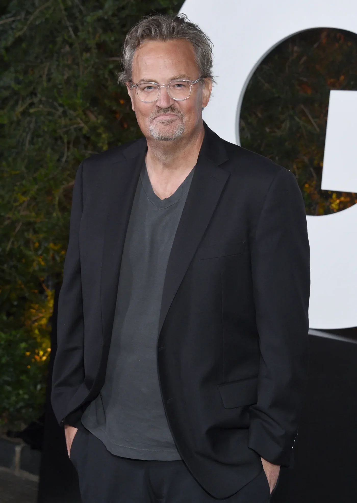 Matthew Perry attends the GQ Men of the Year Party in a black blazer and gray t-shirt.