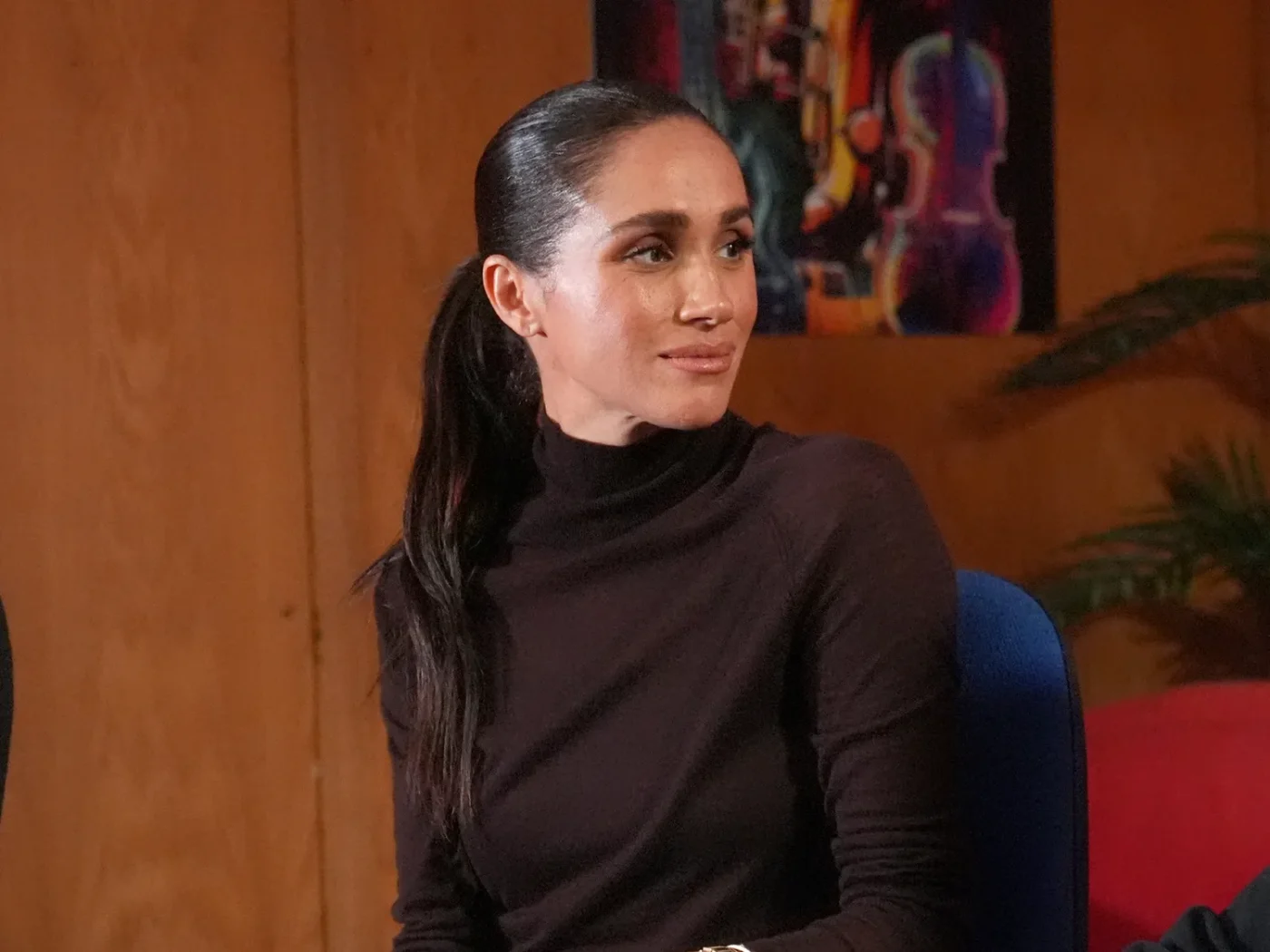 Meghan Markle in a brown top sitting down