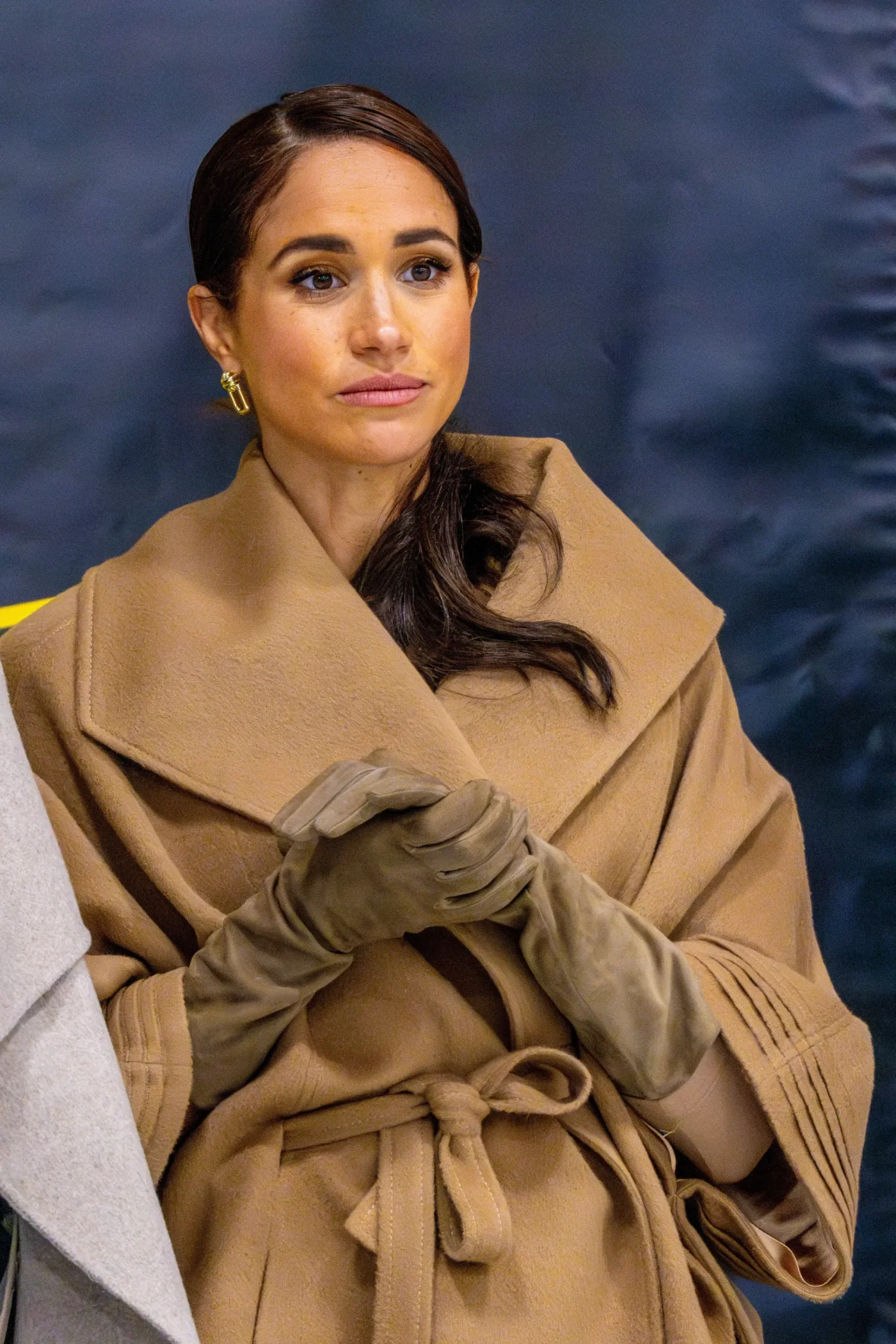 Meghan Markle wearing a tan coat and gloves.