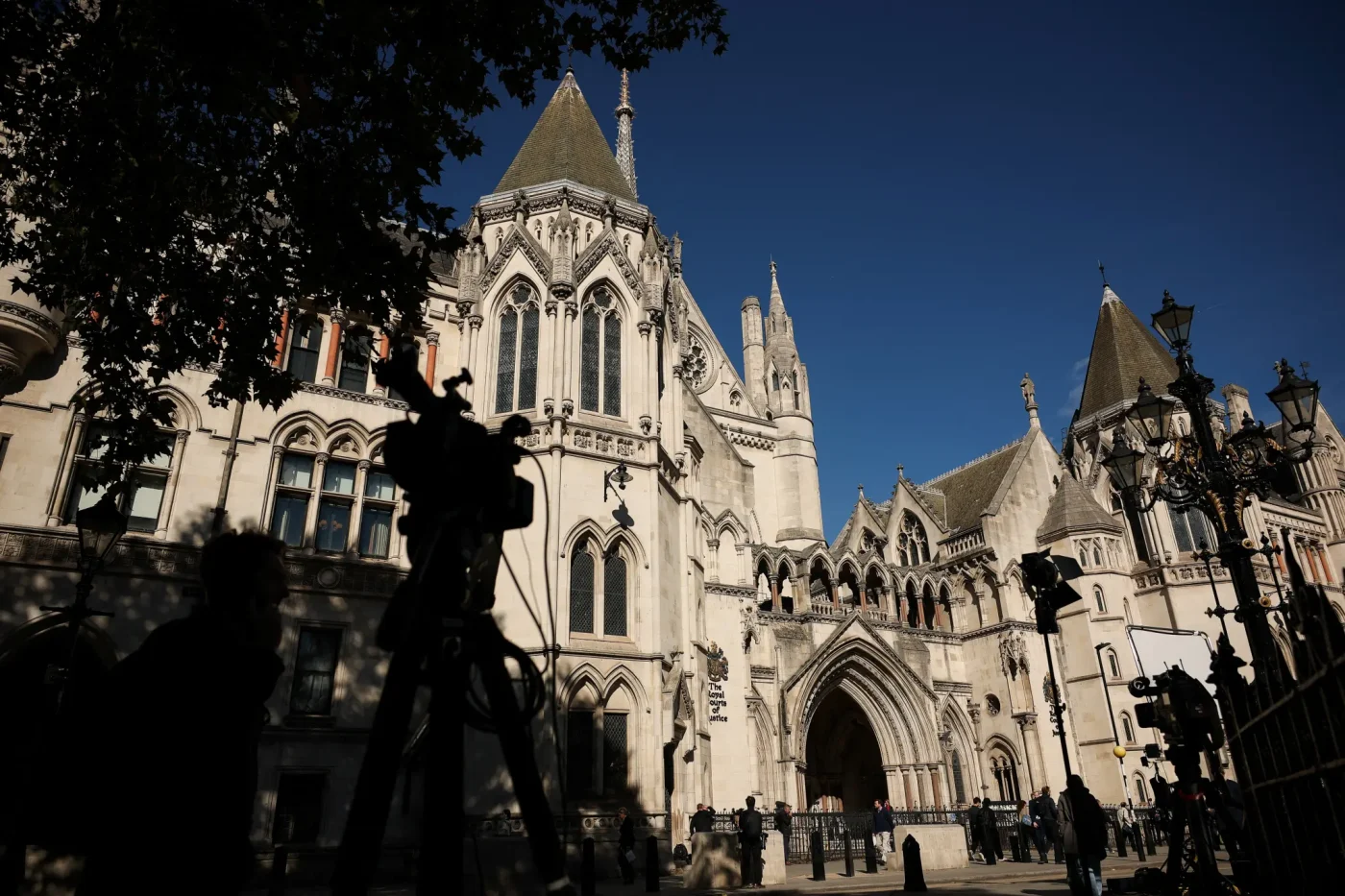 Members of the media and equipment gathered outside the High Court in London.