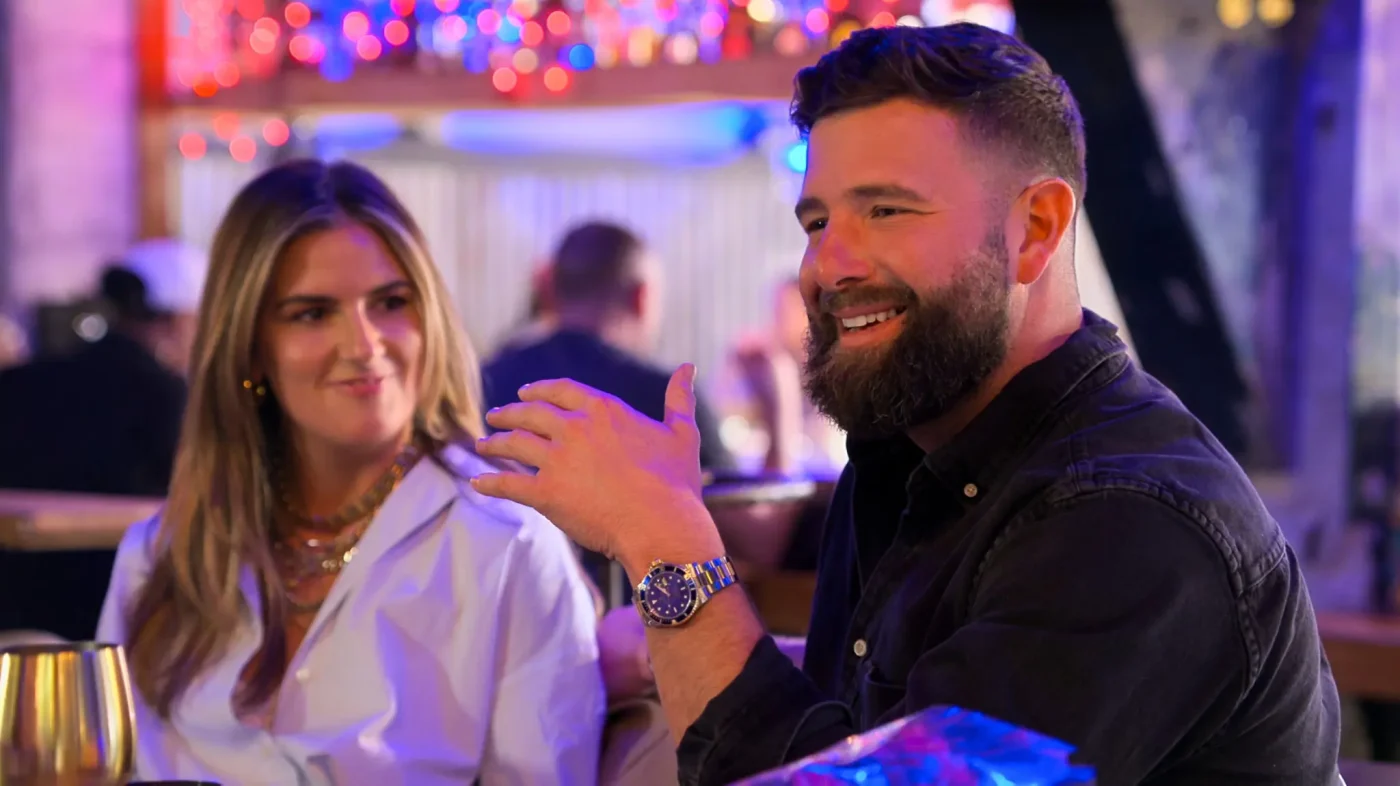 Michaella Giorgio and Rob Feeley sitting together in a restaurant with glowing lights in the background.