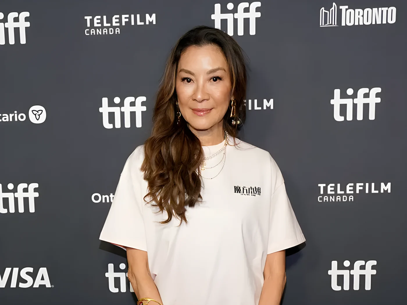 Michelle Yeoh in a white T-shirt with long dark hair