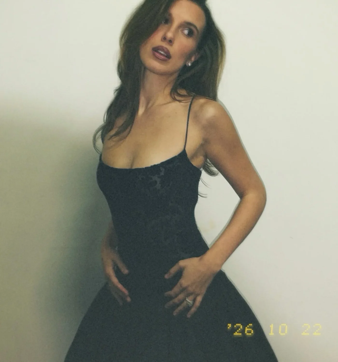 Millie Bobby Brown wearing a dark dress.