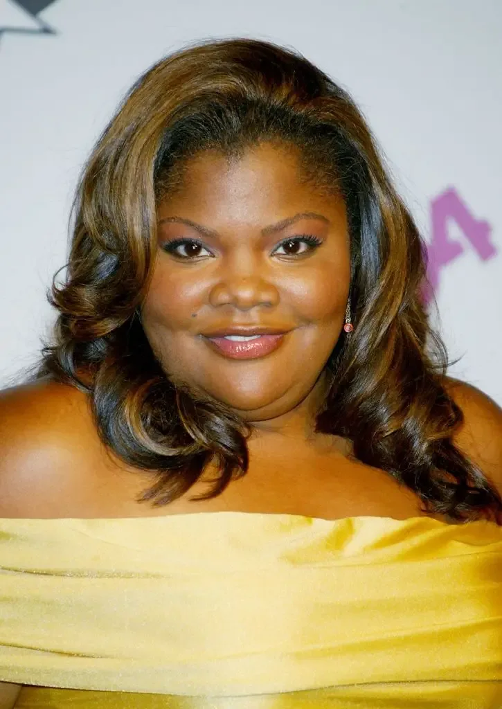Mo'Nique Imes Jackson smiles for photographers in a strapless yellow gown, her wavy hair styled loosely around her shoulders.